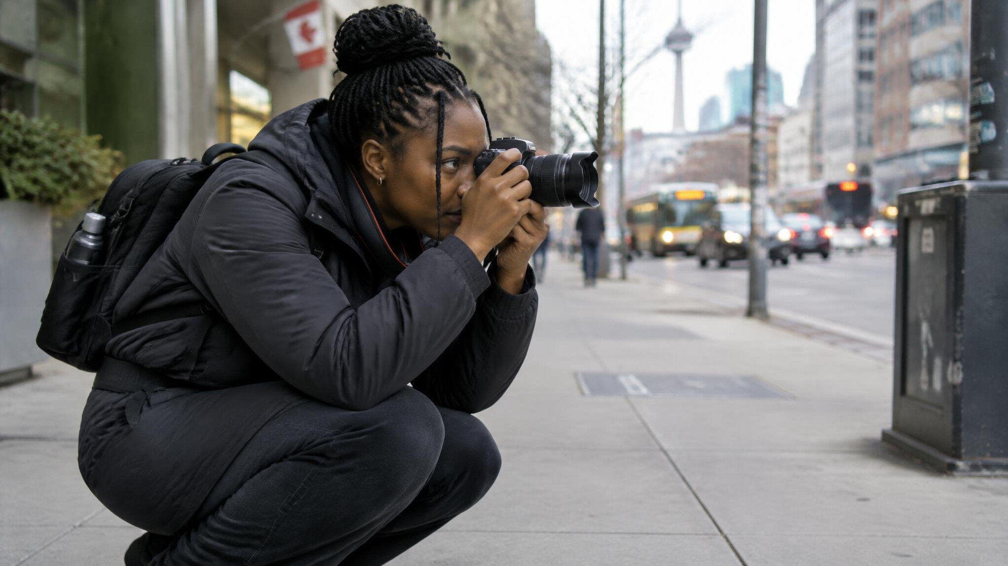 Photographer kneeling to take a photo on a city street