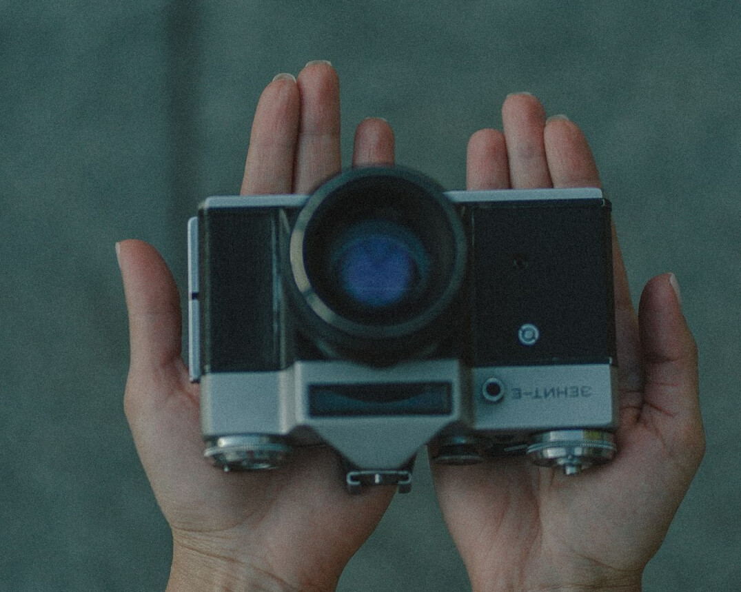 Close-up of hands holding a vintage film camera