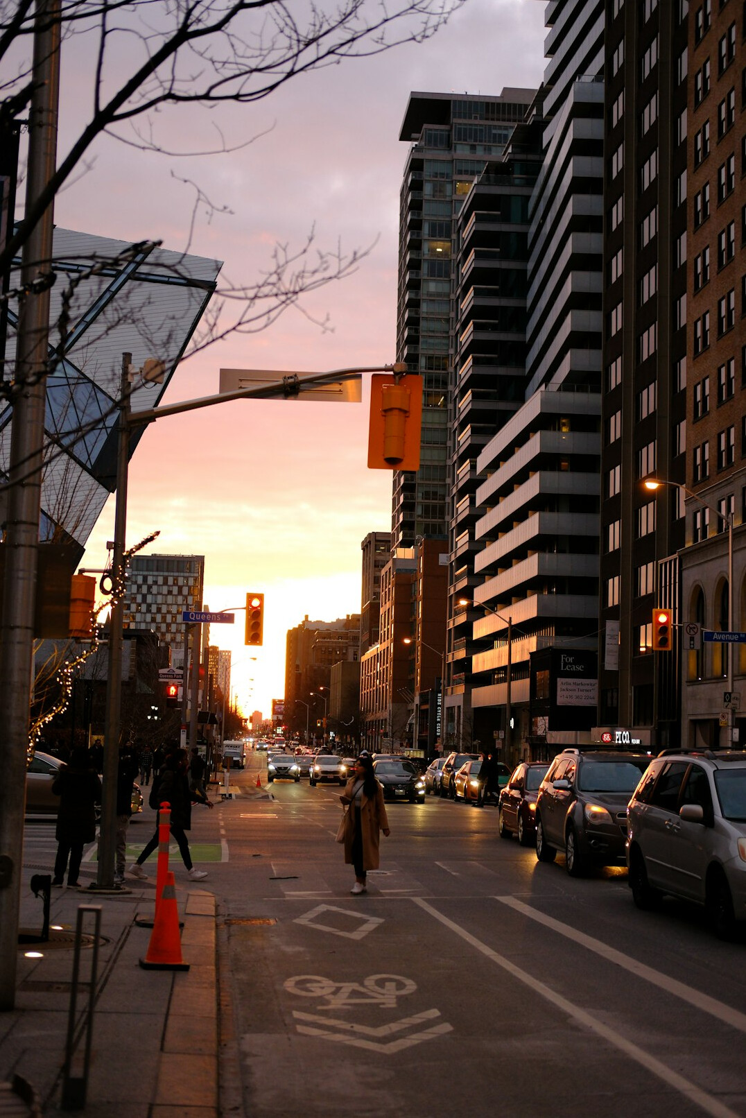 Pedestrians walking along a downtown Toronto street at dusk